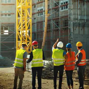 Équipe d'ouvriers SALI BUILDING en gilets et casques de sécurité sur un chantier